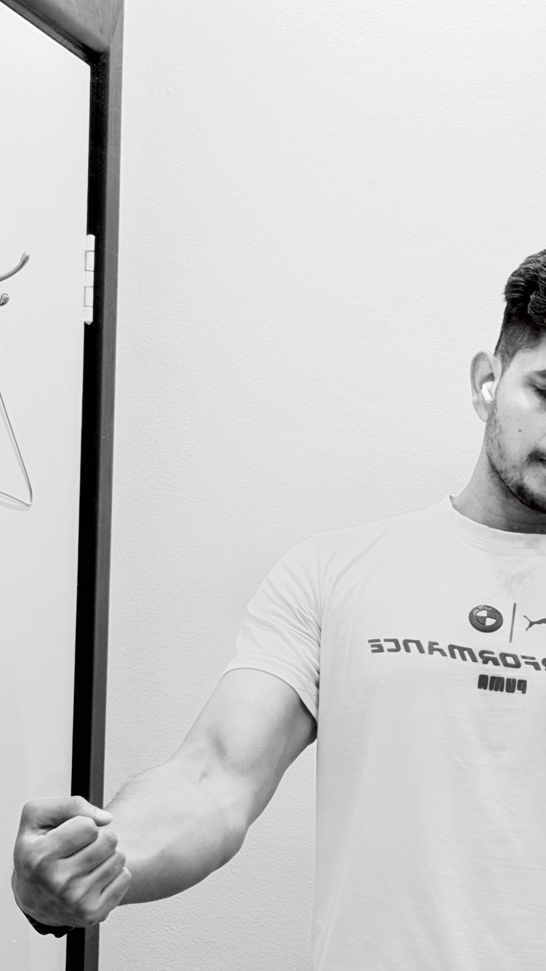 Black and white photo flexing in a gym mirror.