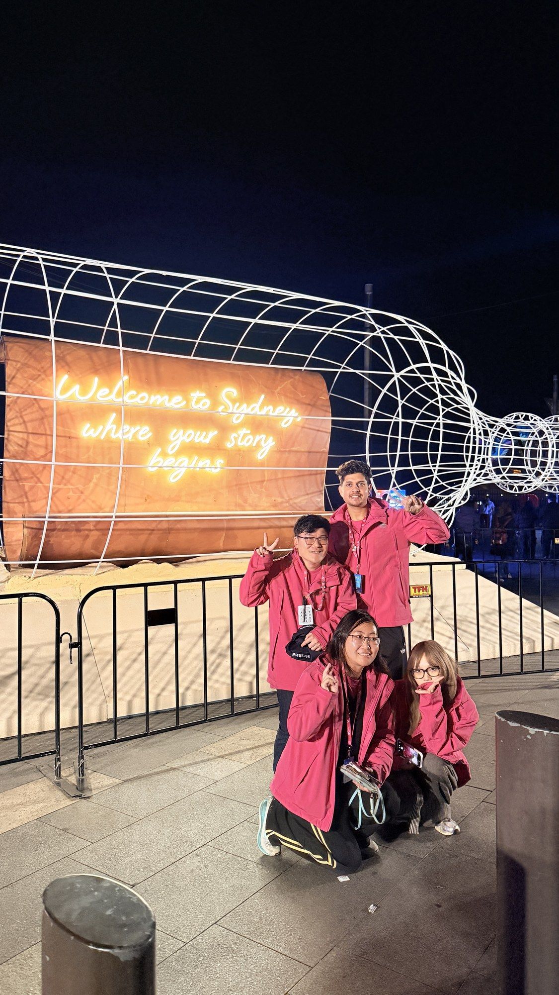 Volunteers posing inside a glowing wire light tunnel at Vivid.