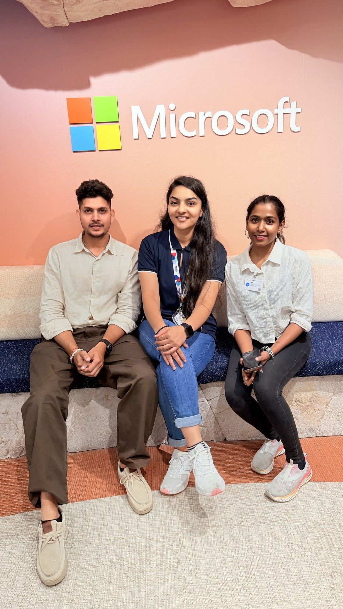 Manish with two attendees seated under the Microsoft logo at Microsoft Sydney.